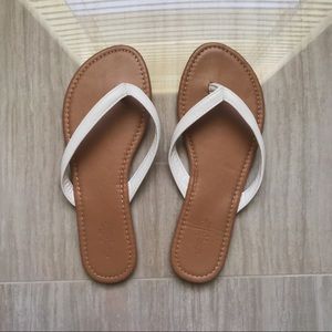 A pair of white leather thong sandals